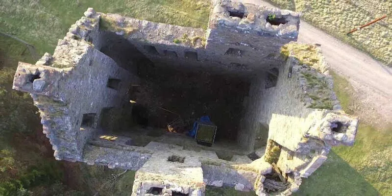 Historic ruins surrounded by green Scottish hills